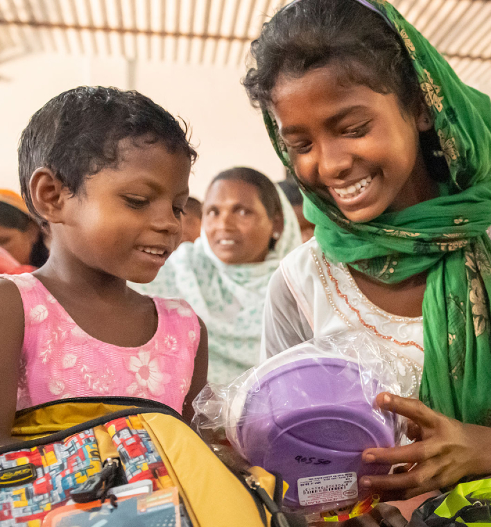 Two girls opening care pack